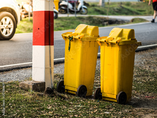 View of two yellow garbages box on the road side.