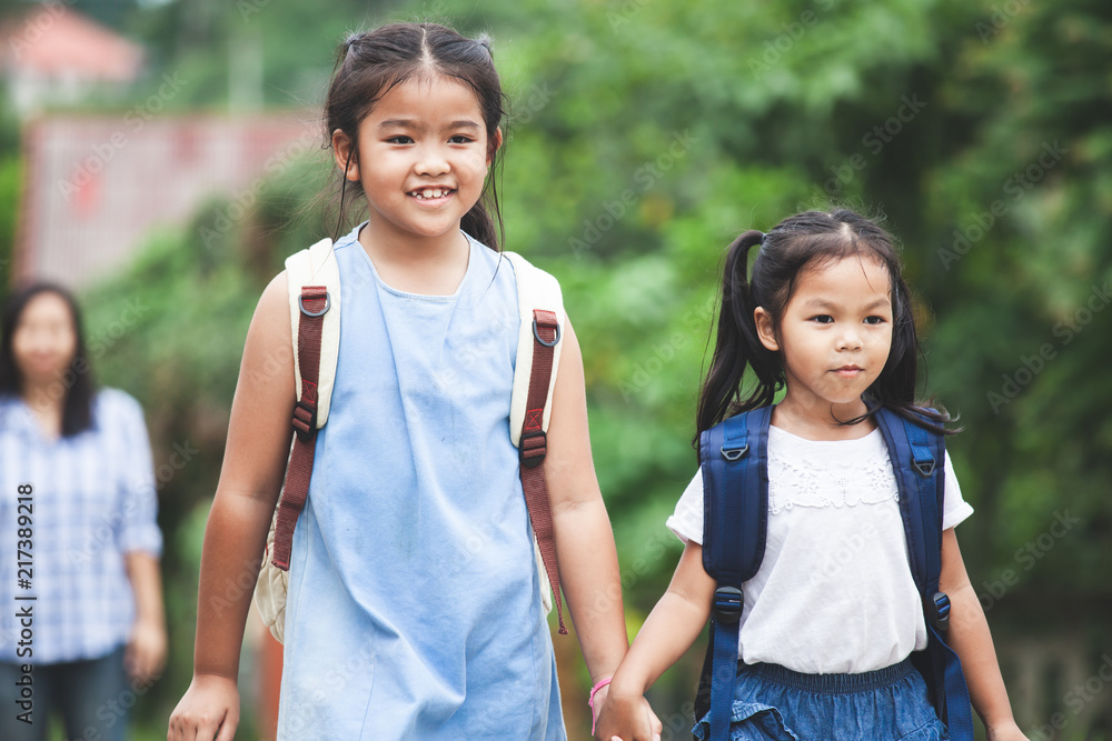 Back to school. Asian pupil kids with backpack holding hand and going to school together Back to school. Asian pupil kids with backpack holding hand and going to school together