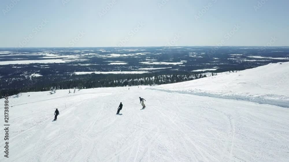 Flying drone behind snowboarders while they are having fun on the slopes and doing tricks. Flying drone behind snowboarders while they are having fun on the slopes and doing tricks.