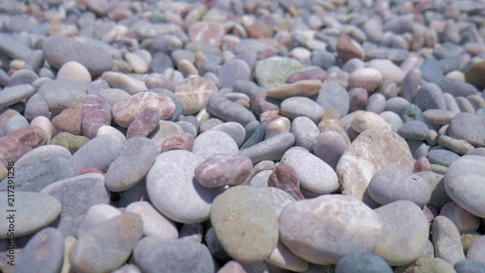 Stones in the sunny beach of Greece filmed in smooth motion. Stones in the sunny beach of Greece filmed in smooth motion.