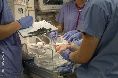 A Newborn Baby Being Helped by Nurses Just after Birth photo