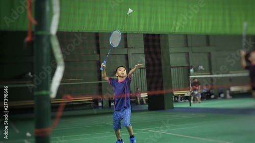 Asian boy playing badminton.