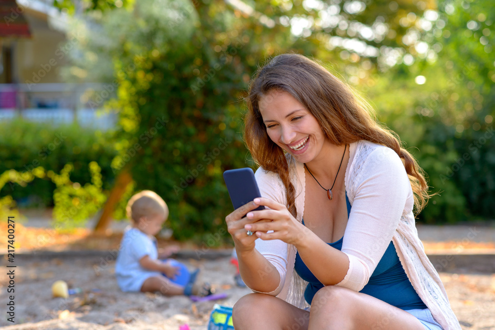 Young mother laughing at a text message Young mother laughing at a text message