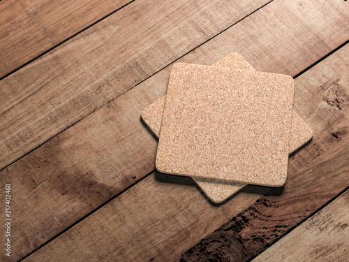 Two square Cork beer coasters Mockup lies on the wooden table photo