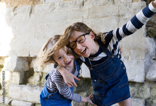 Two sisters playing and holding each other happy