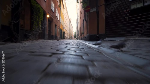 A steady gimbal footage low to the ground in a dark alley in the Old Town of Stockholm Sweden. Early morning, empty streets in the medieval town. Beautiful historic scenery in Gamla Stan. photo