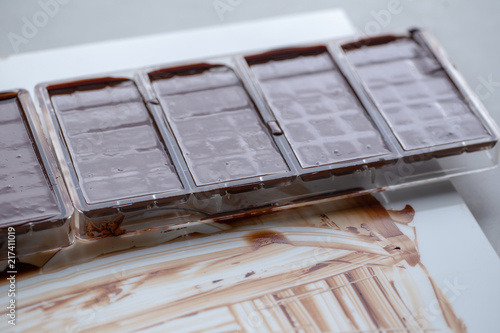 Preparation of dark chocolate bars made from scratch using cocoa butter and sugar photo