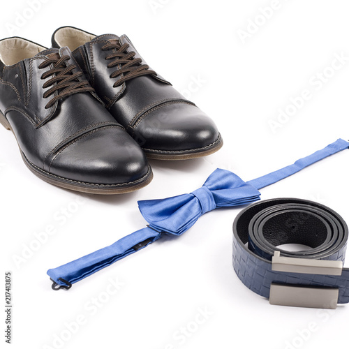Close up of modern man accessories. bow tie, leather shoes, belt on white background.