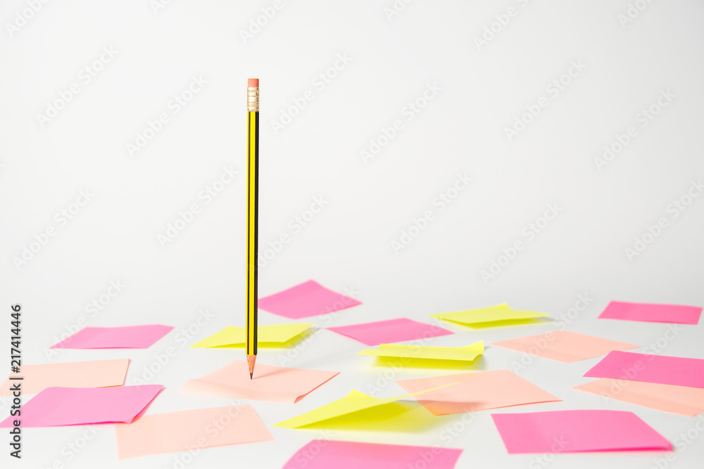 Pencil hanging in the air and stickers on a light background Pencil hanging in the air and stickers on a light background