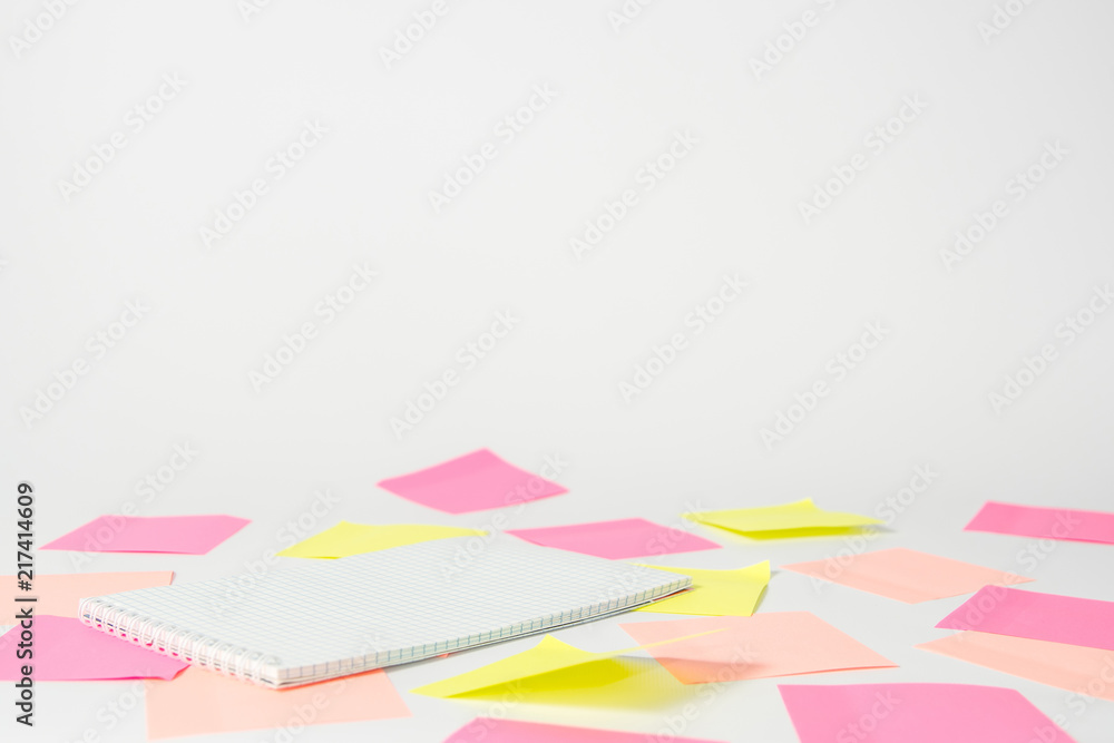 Pink and yellow stickers and notebook lies on a light background. Pink and yellow stickers and notebook lies on a light background.