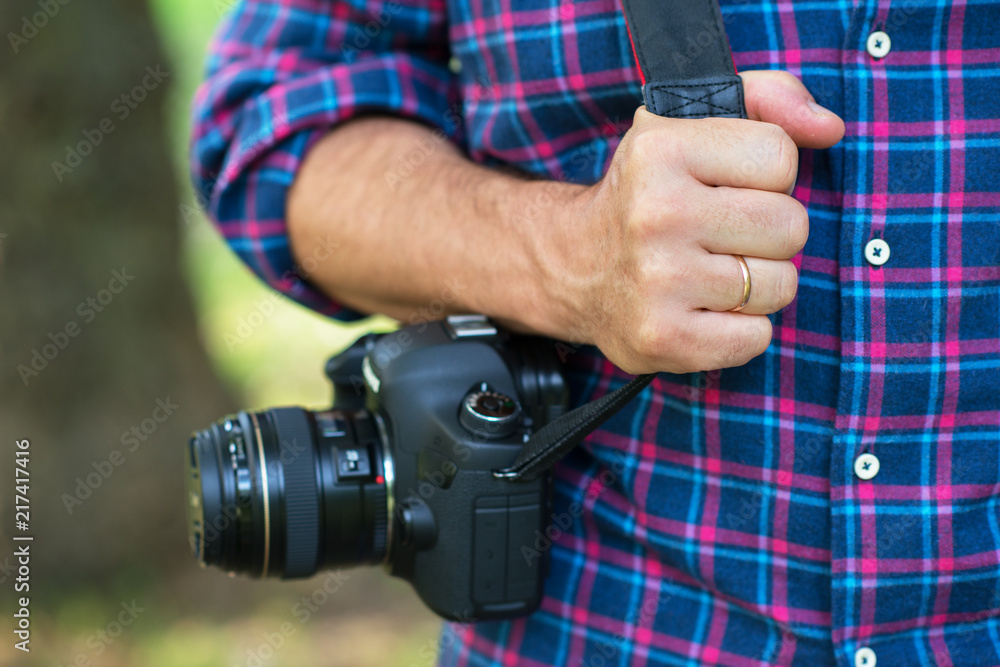 Photographer or traveler concept. Photographer holding digital camera in his hands with copy space blur nature background. Photographer or traveler concept. Photographer holding digital camera in his hands with copy space blur nature background.