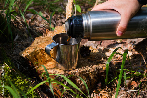 traveler man pours tea from thermos outdoor