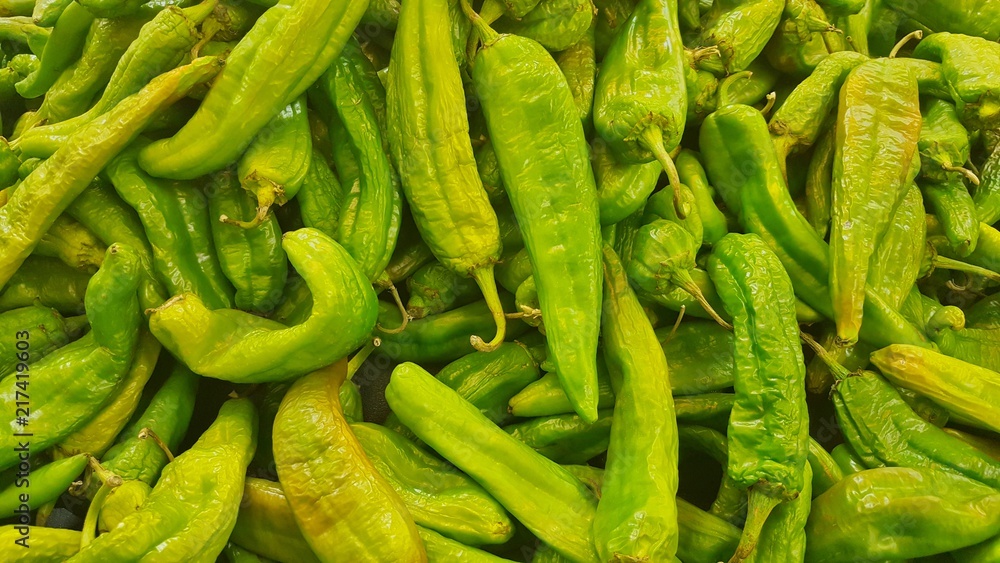 Green Hatch chili peppers many scattered vegetables market hot organic agriculture produce. Green Hatch chili peppers many scattered vegetables market hot organic agriculture produce.