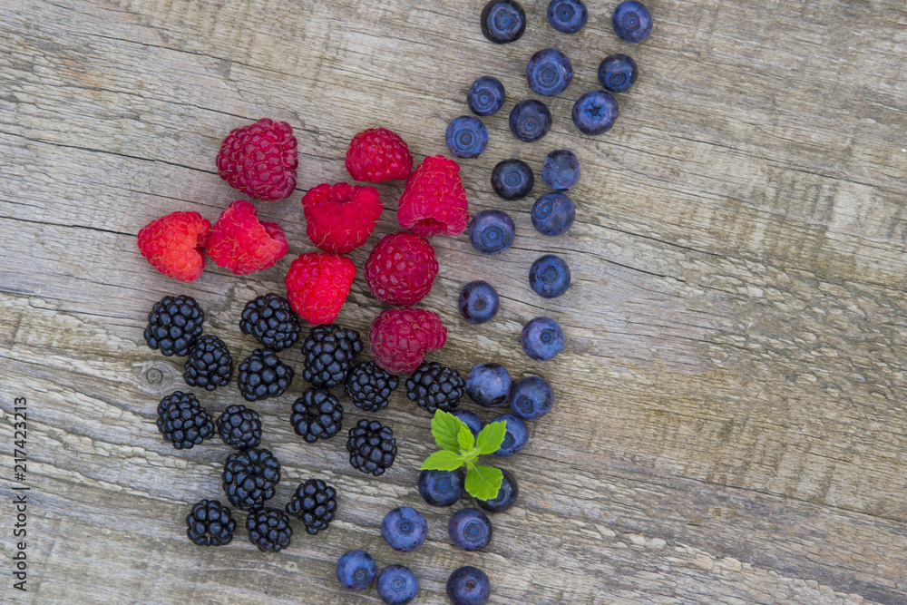 mix of blackberries, raspberries, blueberry on old wooden table background. top view with copy space mix of blackberries, raspberries, blueberry on old wooden table background. top view with copy space