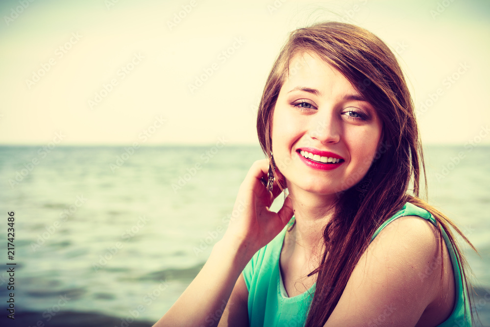 Portrait, happy woman on beach near sea