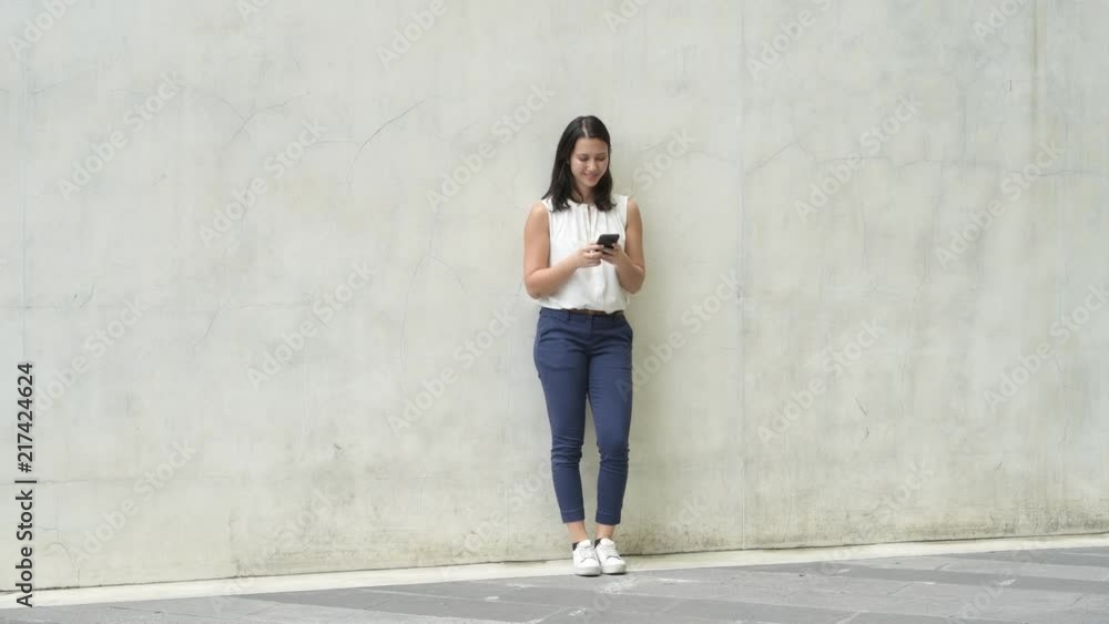 Full Length Shot Of Beautiful Young Woman Standing And Using Mobile Phone Outdoors Full Length Shot Of Beautiful Young Woman Standing And Using Mobile Phone Outdoors