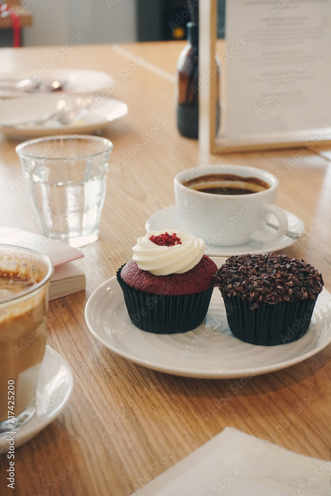 two testy cupcakes with the coffee cups in the cafe