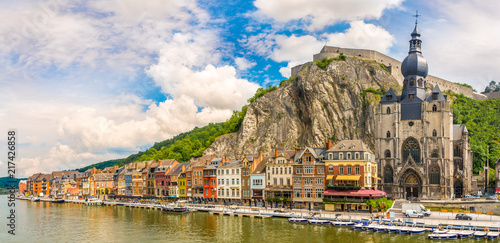 Panoramic vew at the embankment of Meuse river with houses and church of Our Lady Assumption in Dinant - Belgium photo