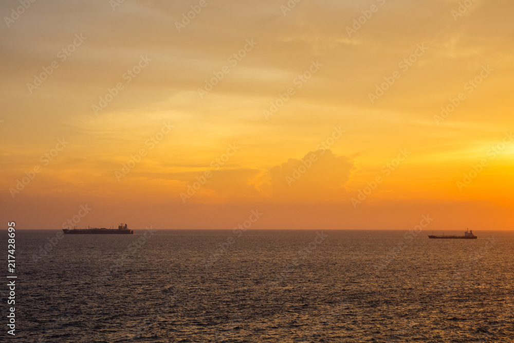 Sunset at the Sea with boat and cloudy sky