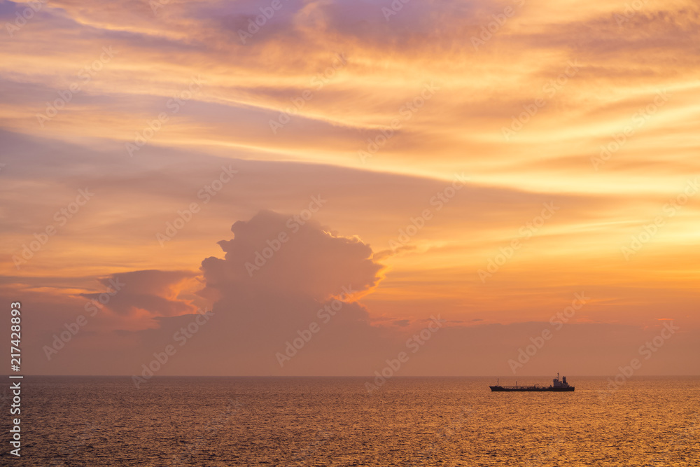 Sunset at the Sea with boat and cloudy sky