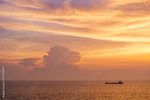 Sunset at the Sea with boat and cloudy sky