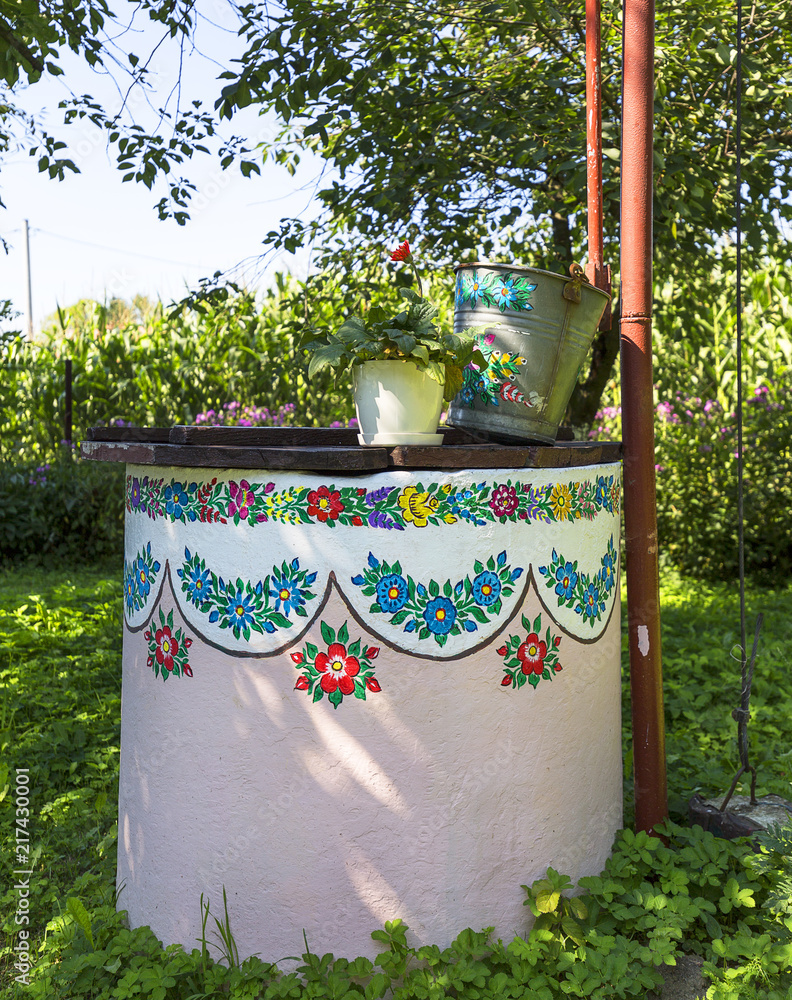 Painted old well decorated with a hand painted colorful floral motives, folk art, Zalipie, Poland
