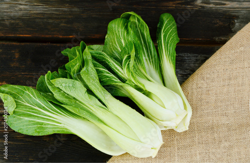 Принти на полотні Fresh Bok choy or pak choi and water drop on wooden background and sack cloth