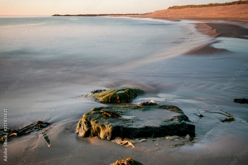 vening seascape beach scene with waves and blue sky and yellow sand dunes vening seascape beach scene with waves and blue sky and yellow sand dunes