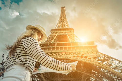 Woman tourist selfie near the Eiffel Tower in Paris under sunlight © Andrii IURLOV