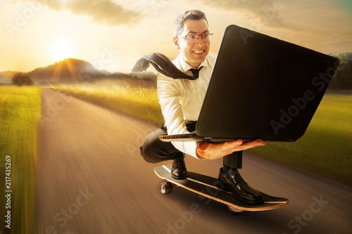Geschäftsmann mit Laptop auf Skateboard