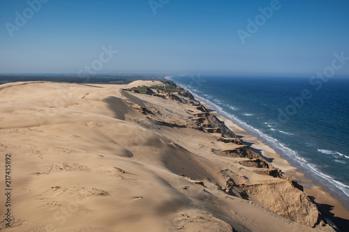 Panorama view of the danish sand cliff and dunes with blue ocean and bright summer sun light. Rubjerg Knude Lighthouse  L  nstrup in North Jutland in Denmark  Skagerrak  North Sea