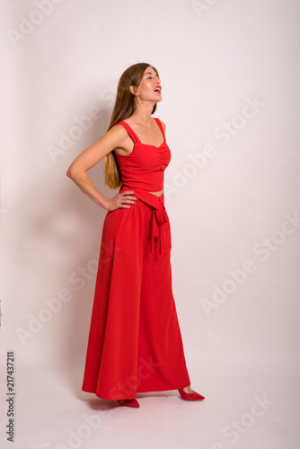 female Model Against white Studio Background in red suit