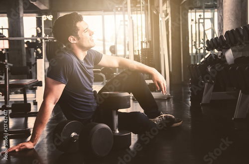 handsome young man sitting in gym . relaxing feel after work out exercise in club