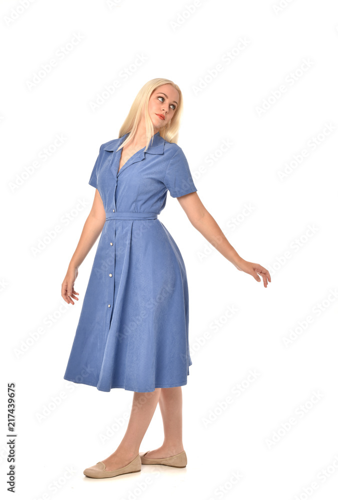 full length portrait of blonde girl wearing blue dress. standing pose. isolated on white studio background. full length portrait of blonde girl wearing blue dress. standing pose. isolated on white studio background.