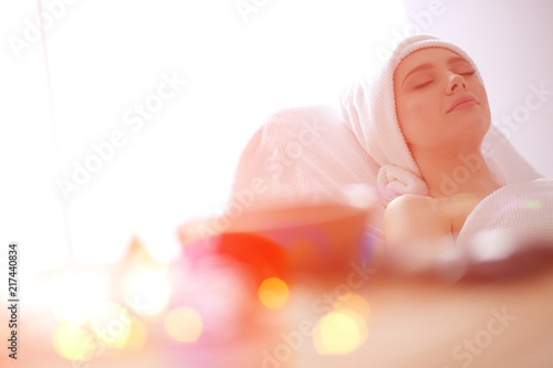 Young woman lying on a massage table,relaxing with eyes closed. Woman. Spa salon photo