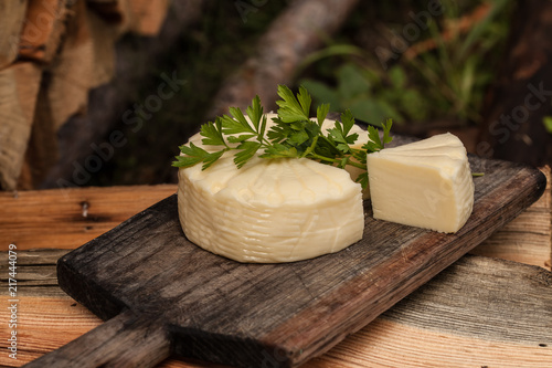 Wheel of brazilian traditional cheese Minas on wooden board. Selective focus