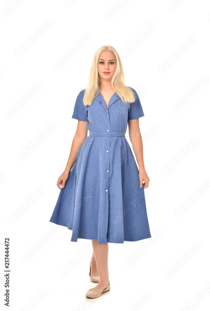 full length portrait of blonde girl wearing blue dress. standing pose. isolated on white studio background. full length portrait of blonde girl wearing blue dress. standing pose. isolated on white studio background.