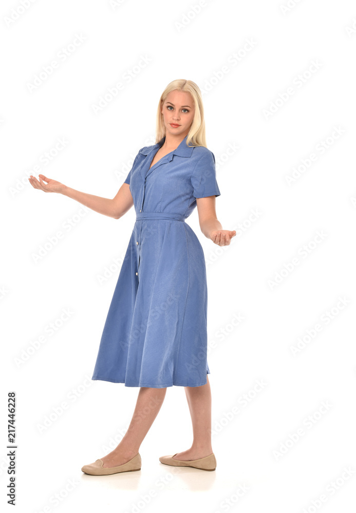 full length portrait of blonde girl wearing blue dress. standing pose. isolated on white studio background. full length portrait of blonde girl wearing blue dress. standing pose. isolated on white studio background.