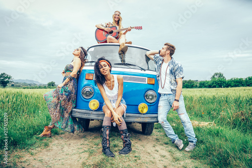 Fototapeta Happy friends driving a vintage minivan