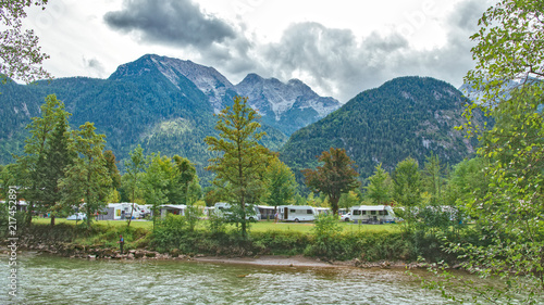 Sommer Campingplatz in den Bergen mit Wohnwagen und Zelten an einem Fluß photo