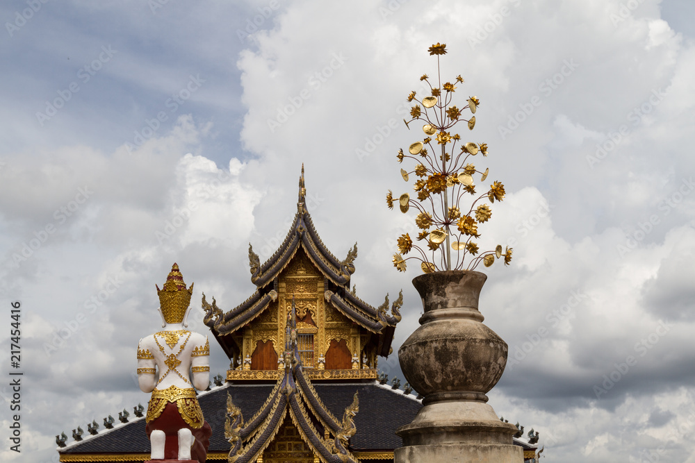 Buddhist background with amazing cloudy sky, buddhist statue, traditional temple and golden flower at Wat Bandensali temple in Thailand