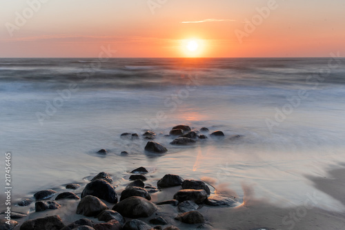 Sunset evening beach overview with waves and wet stones. Danish coastline, Hirtshals in North Jutland in Denmark, Skagerrak, North Sea