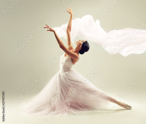     Ballerina. Young graceful woman ballet dancer, dressed in professional outfit, shoes and white weightless skirt is demonstrating dancing skill. Beauty of classic ballet. 
