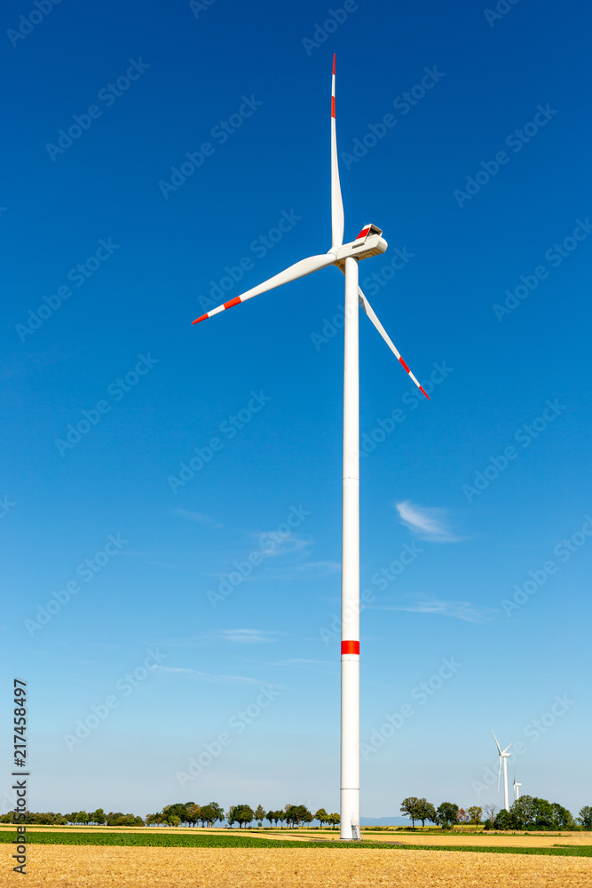 Wind turbine generating electricity on a bright blue sky. Wind turbine generating electricity on a bright blue sky.