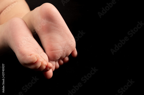 newborn baby feet isolated on black background