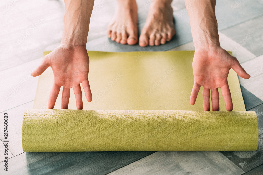 sport fitness and stamina training. physical exercising for strong body and  healthy mind. man hands rolling out yoga mat on the floor. Stock Photo |  Adobe Stock