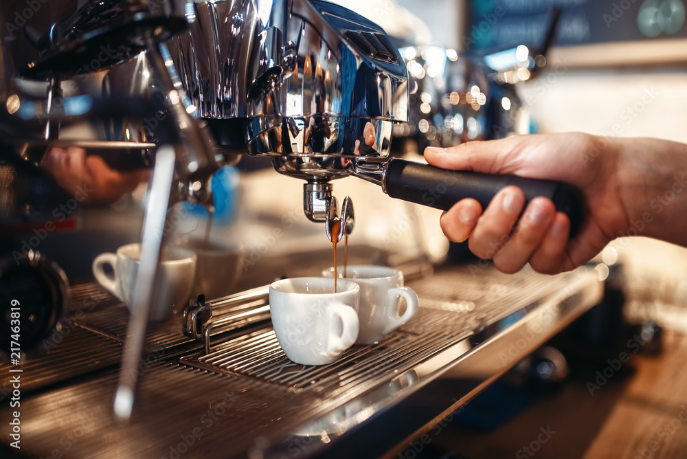 Barista hand pours beverage from coffee machine Barista hand pours beverage from coffee machine