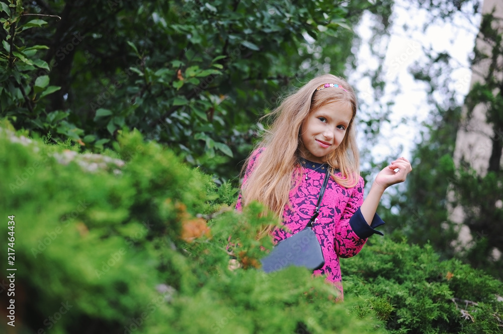 A teen girl in a beautiful pink dress is having a rest in nature with her friends. The girl is happy and smiles because she breathes clean air outside the city A teen girl in a beautiful pink dress is having a rest in nature with her friends. The girl is happy and smiles because she breathes clean air outside the city