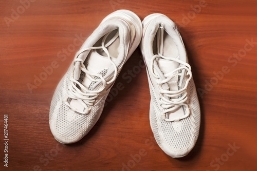 Sports white sneakers on a wooden background. Top view