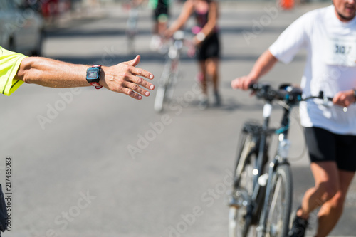 Race official, transition marshall directs triathlon athletes to the transition area after bike course © michelmond